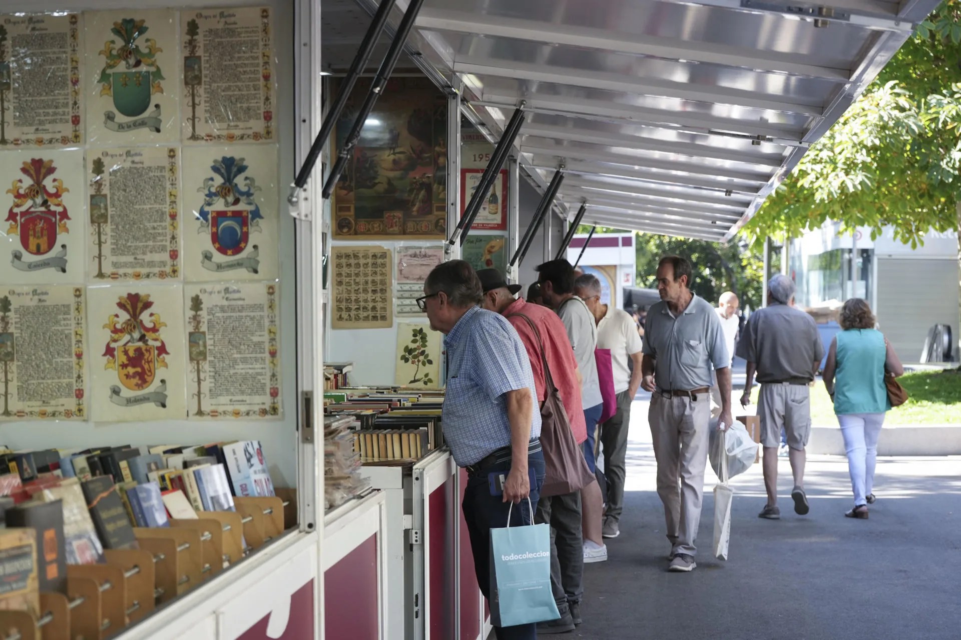 Varias personas ojean los ejemplares de los stands situados en el Paseo de Recoletos donde desde este jueves y hasta el próximo 12 de octubre 34 librerías especializadas de toda España participan en la Feria de Otoño del Libro Viejo y Antiguo de Madrid. EFE/ Nahia Peciña