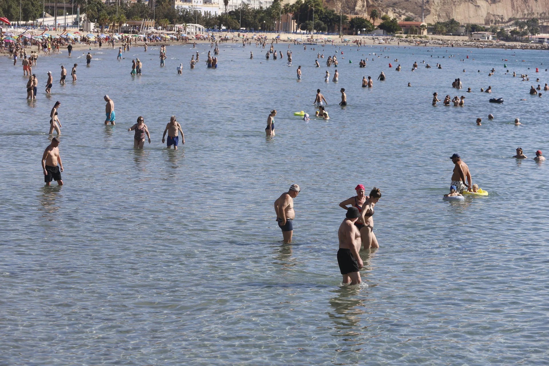 Varias personas disfrutan en la playa de El Postiguet, de las altas temperaturas registradas este martes en Alicante. EFE/Morell
