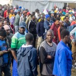 Migrantes malauíes en Sudáfrica hacen fila para recibir suministros en un campamento de refugiados informal en Sherwood