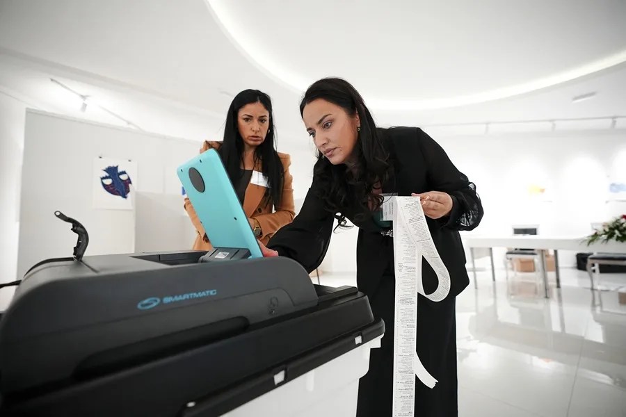 Unos votantes se disponen a introducir una papeleta de papel en un escáner óptico en un colegio electoral durante las elecciones generales en Banja Luka, Bosnia y Herzegovina