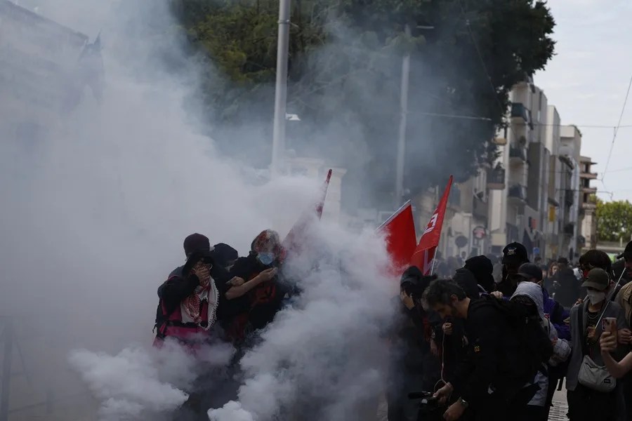Estudiantes de secundaria permanecen en medio de gases lacrimógenos mientras estallan enfrentamientos entre alumnos y la policía antidisturbios