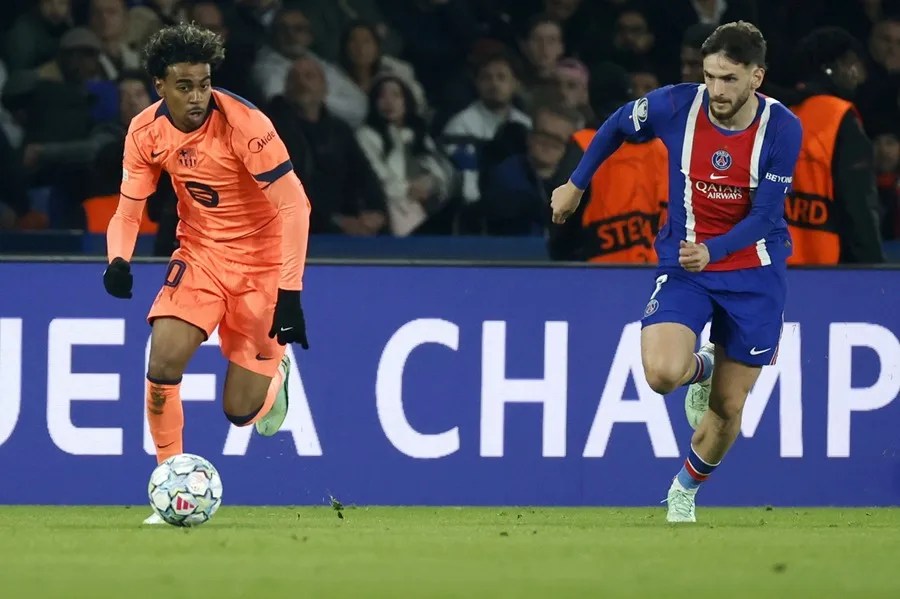 Lamine Yamal (i) del Barcelona y Khvicha Kvaratskhelia (d) del París en acción durante el partido de fase de la Liga de Campeones
