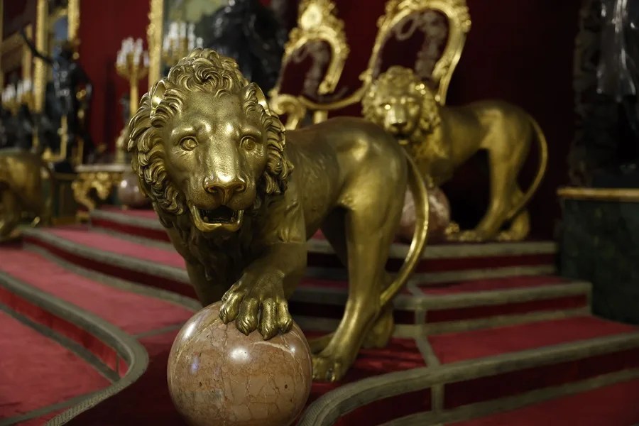Regios leones montan guardia a ambos lados de los tronos.