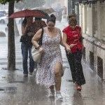 Varias jóvenes corren bajo la intensa lluvia