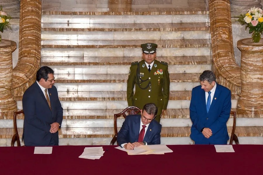 Rodrigo Paz (c) firmando un documento en un acto de promulgación de una ley este viernes, en La Paz (Bolivia)