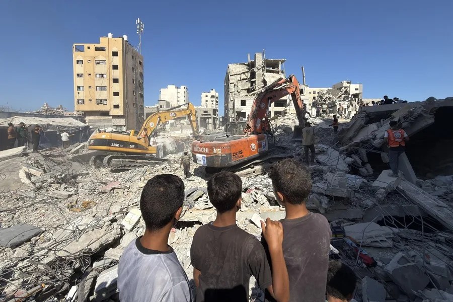 Unos niños gazatíes observan el derrumbe de un edificio residencial de seis plantas en la Franja de Gaza.