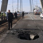 Personas inspeccionan el lugar de un ataque con drones rusos contra un puente sobre el río Dniéper en Kiev