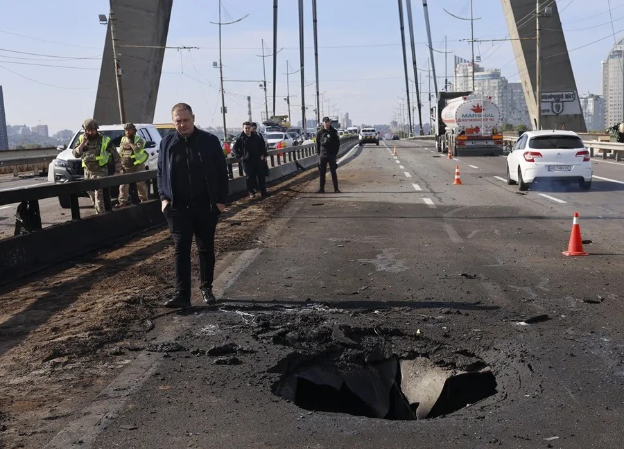 Personas inspeccionan el lugar de un ataque con drones rusos contra un puente sobre el río Dniéper en Kiev