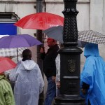 Turistas protegiéndose de la lluvia en Oviedo.