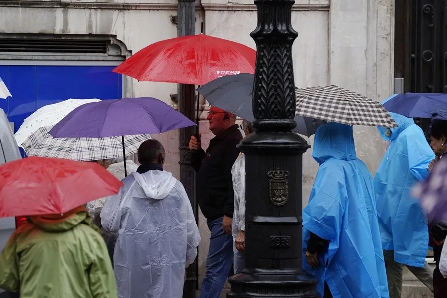 Turistas protegiéndose de la lluvia en Oviedo.