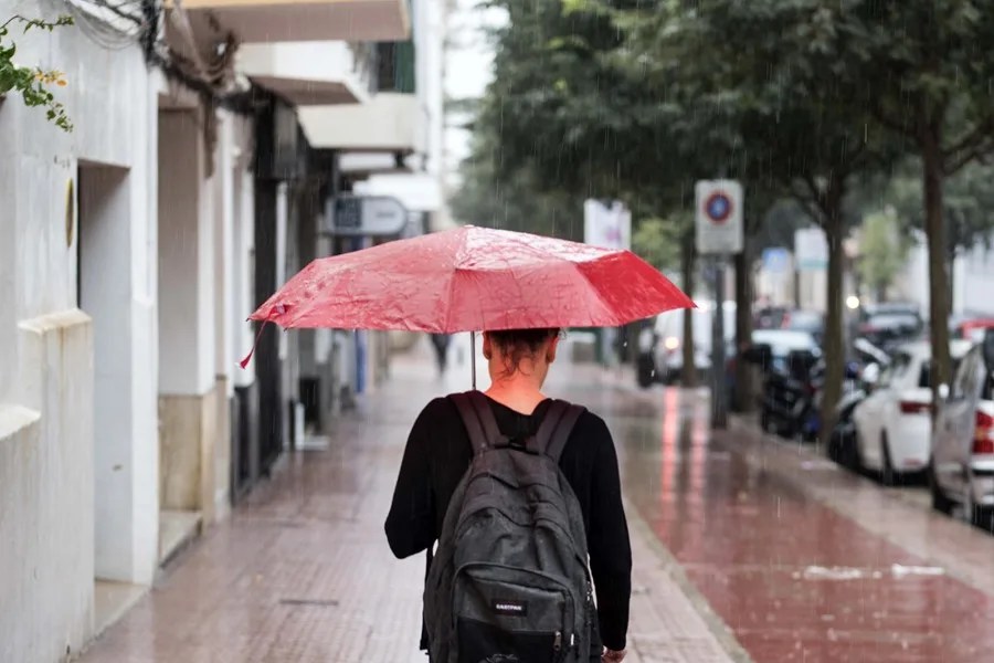 Una mujer se protege de la lluvia con un paraguas