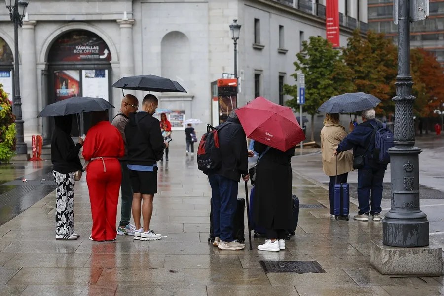 Viandantes se protegen de la lluvia en el centro de Madrid