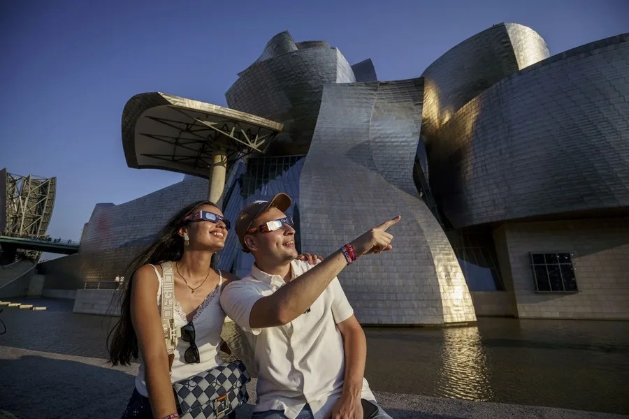 Una pareja, con el Museo Guggenheim de Bilbao al fondo.