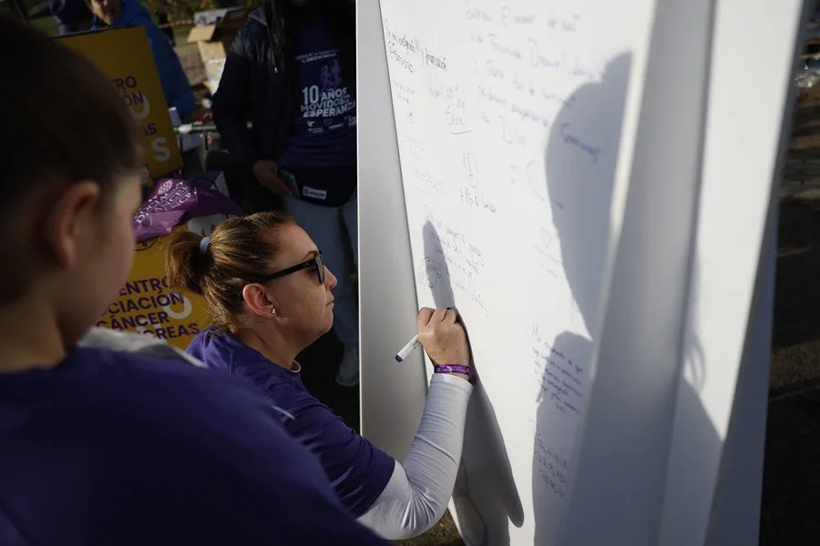 Una participante escribe un mensaje de apoyo antes del inicio de la Carrera de las Ciudades contra el Cáncer de Páncreas