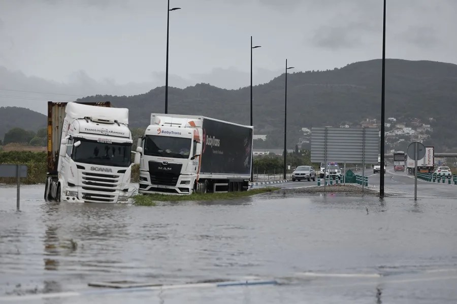 Varios camiones atrapados en una zona inundada en la N332, a las afueras de Gandía, este lunes.