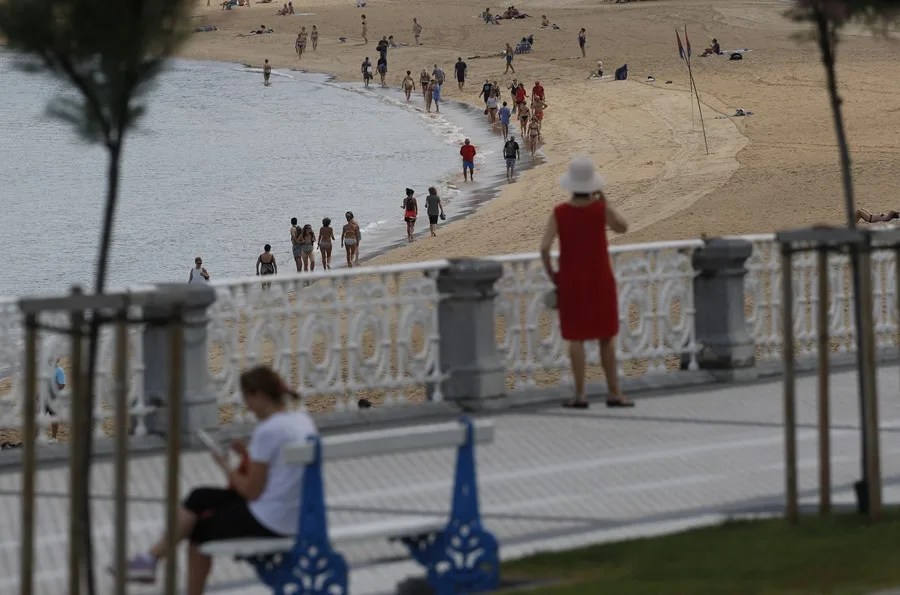 Donostiarras y visitantes pasean este lunes por la playa de la Concha