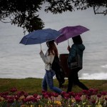 Dos jóvenes pasean junto a la costa en San Sebastián