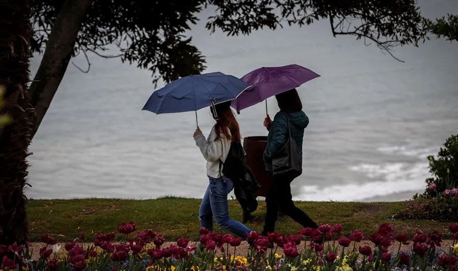 Dos jóvenes pasean junto a la costa en San Sebastián