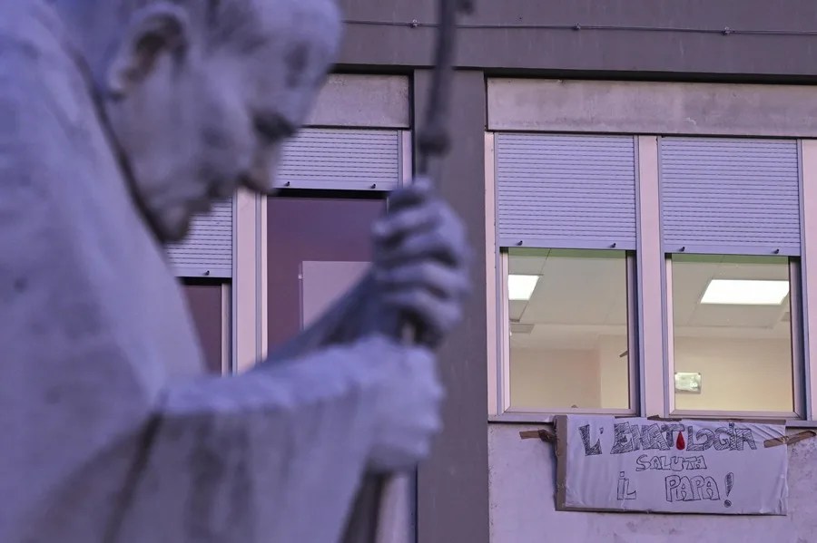 Una pancarta dedicada al Papa León en una ventana frente a la estatua de Juan Pablo II, en el exterior del Hospital Universitario Agostino Gemelli