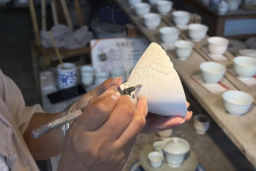 Un artista decora una taza de porcelana china en la cuna de este arte, en Jingdezhen (China)
