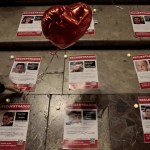 Una persona coloca unos carteles de rehenes capturados por Hamás en su ataque del pasado 7 de octubre.
