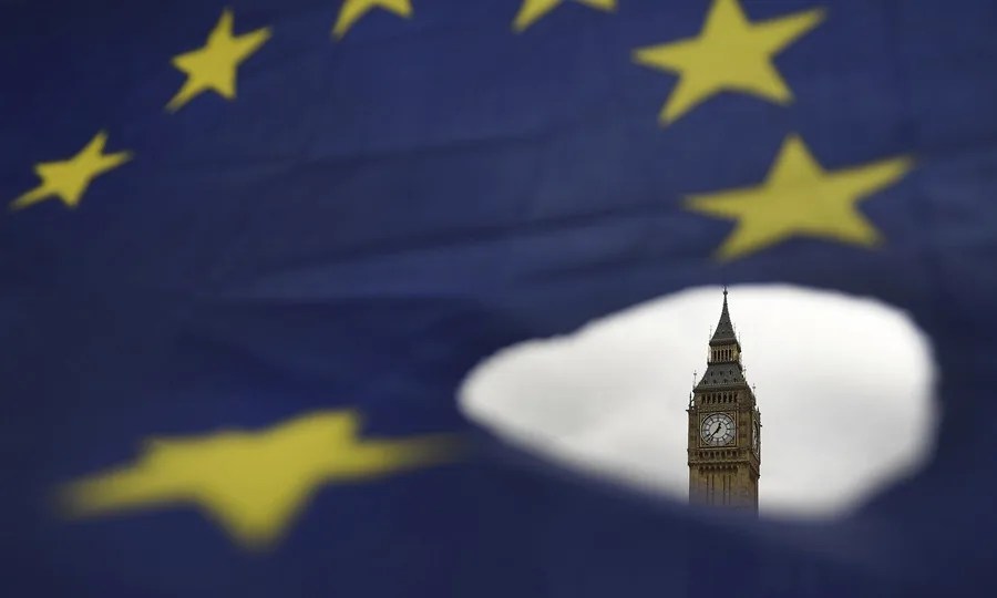 El Big Ben asoma por un roto en una bandera de la Unión Europea en Londres