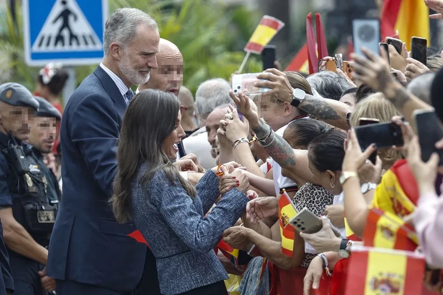 El rey Felipe VI (i, atrás) y la reina Letizia (c) saludan a la multitud que espera su llegada ante el Ayuntamiento de Ceuta, este martes.
