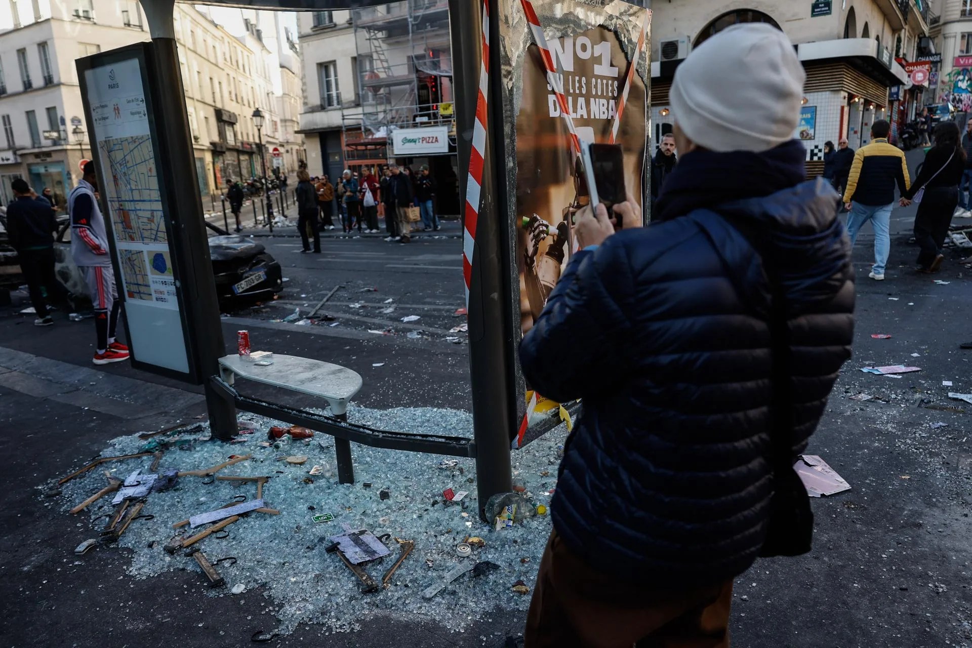 A man takes a photograph of damages in the aftermath of clashes between riot police and demonstrators during nationwide protests against the high cost of living in the country, in Paris, France, 18 October 2026. EFE-EPA/MOHAMMED BADRA
