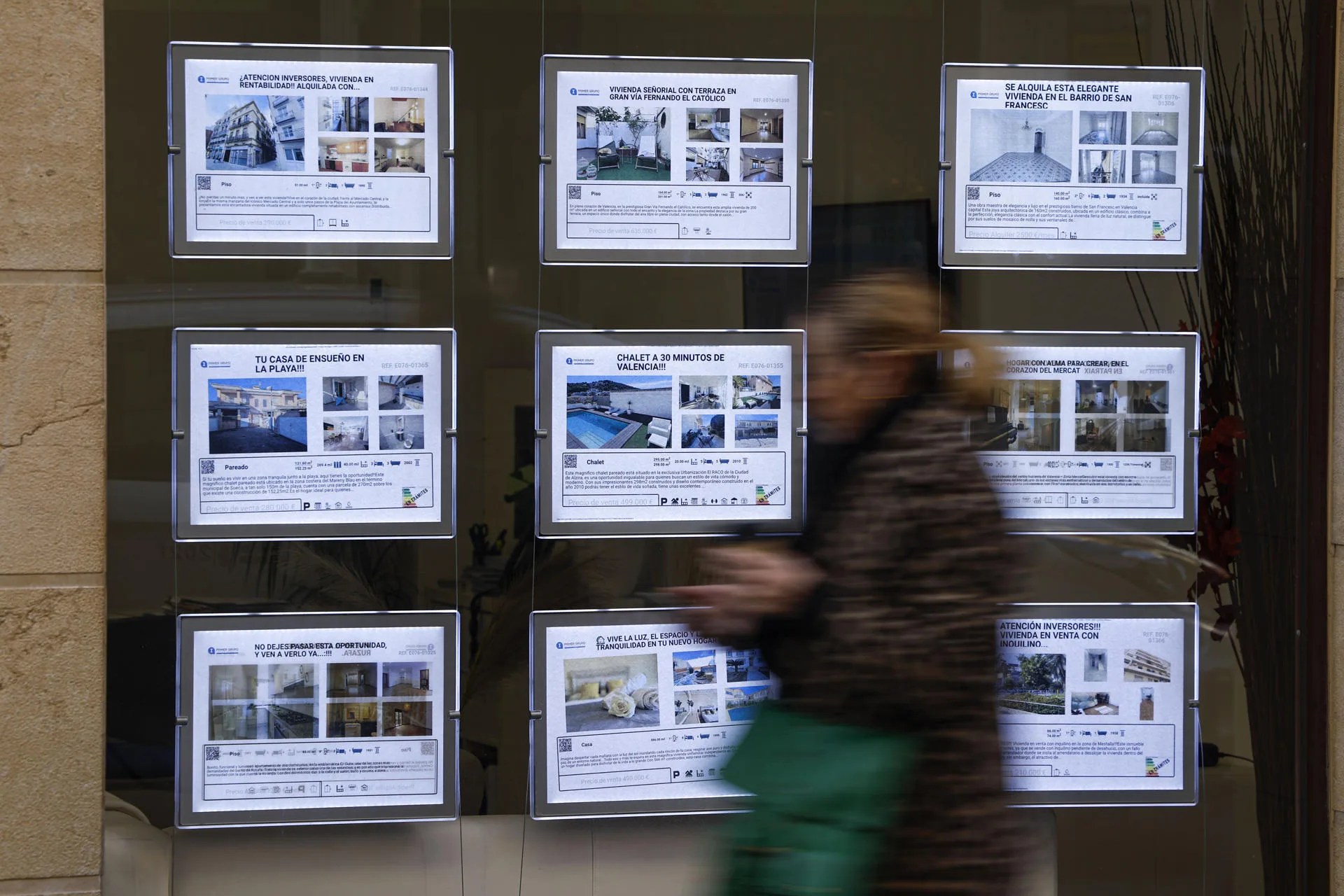 Una persona pasa ante los anuncios de venta y alquiler de vivienda en una inmobiliaria de Valéncia. EFE/Biel Aliño