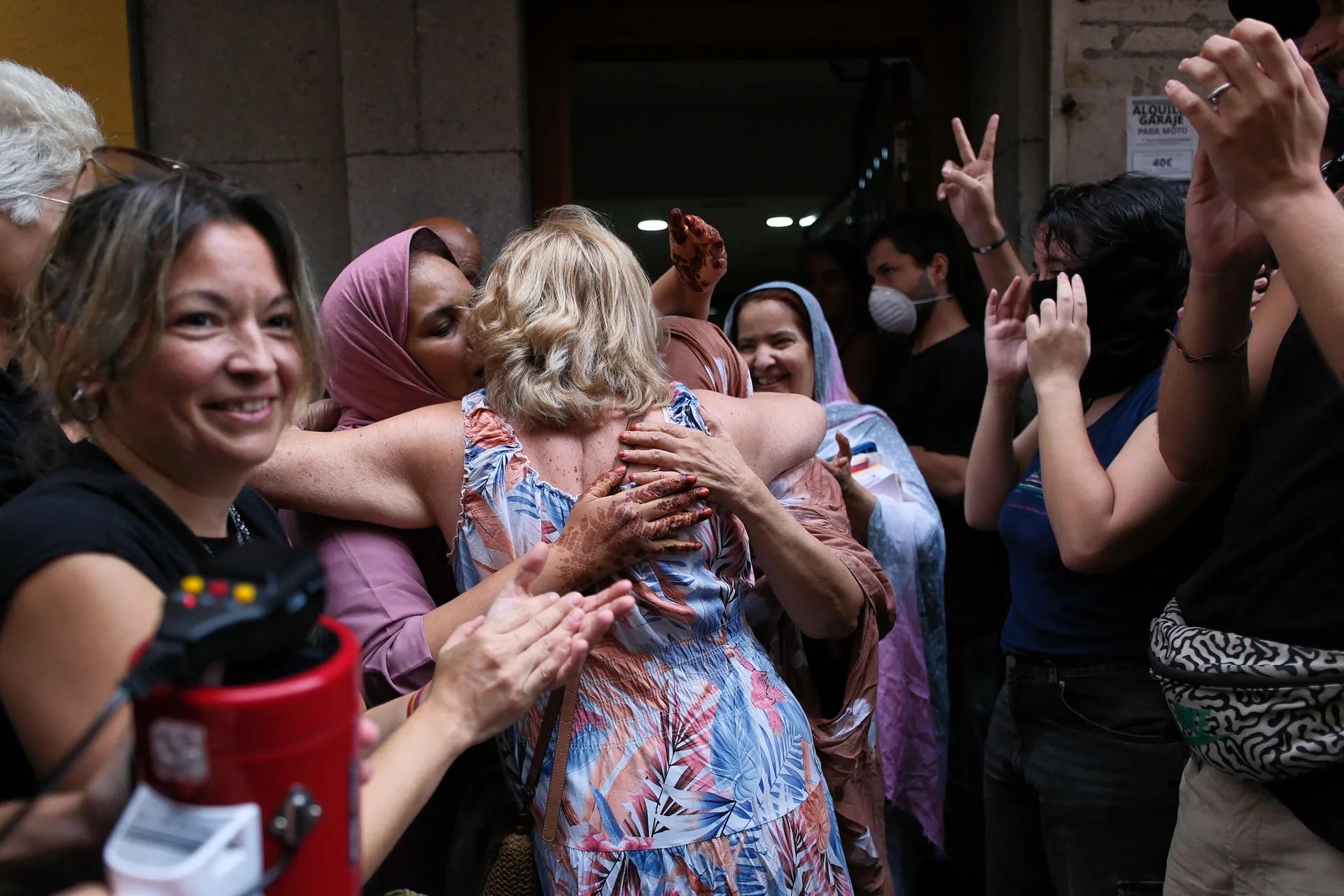 Inquilinos del edificio de la calle Nicolás Estévanez, vecinos del barrio y activistas de la plataforma ciudadana Derecho al Techo celebran la suspensión del desahucio. EFE/Ángel Medina G.
