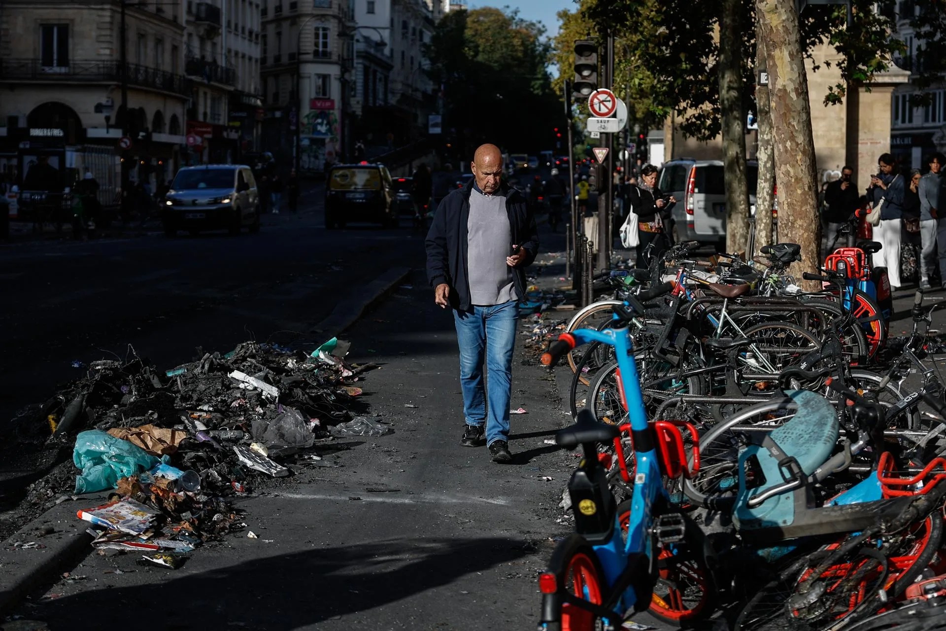 A man walks past debris left in the street in the aftermath of clashes between riot police and demonstrators during nationwide protests against the high cost of living in the country, in Paris, France, 18 October 2026. EFE-EPA/MOHAMMED BADRA