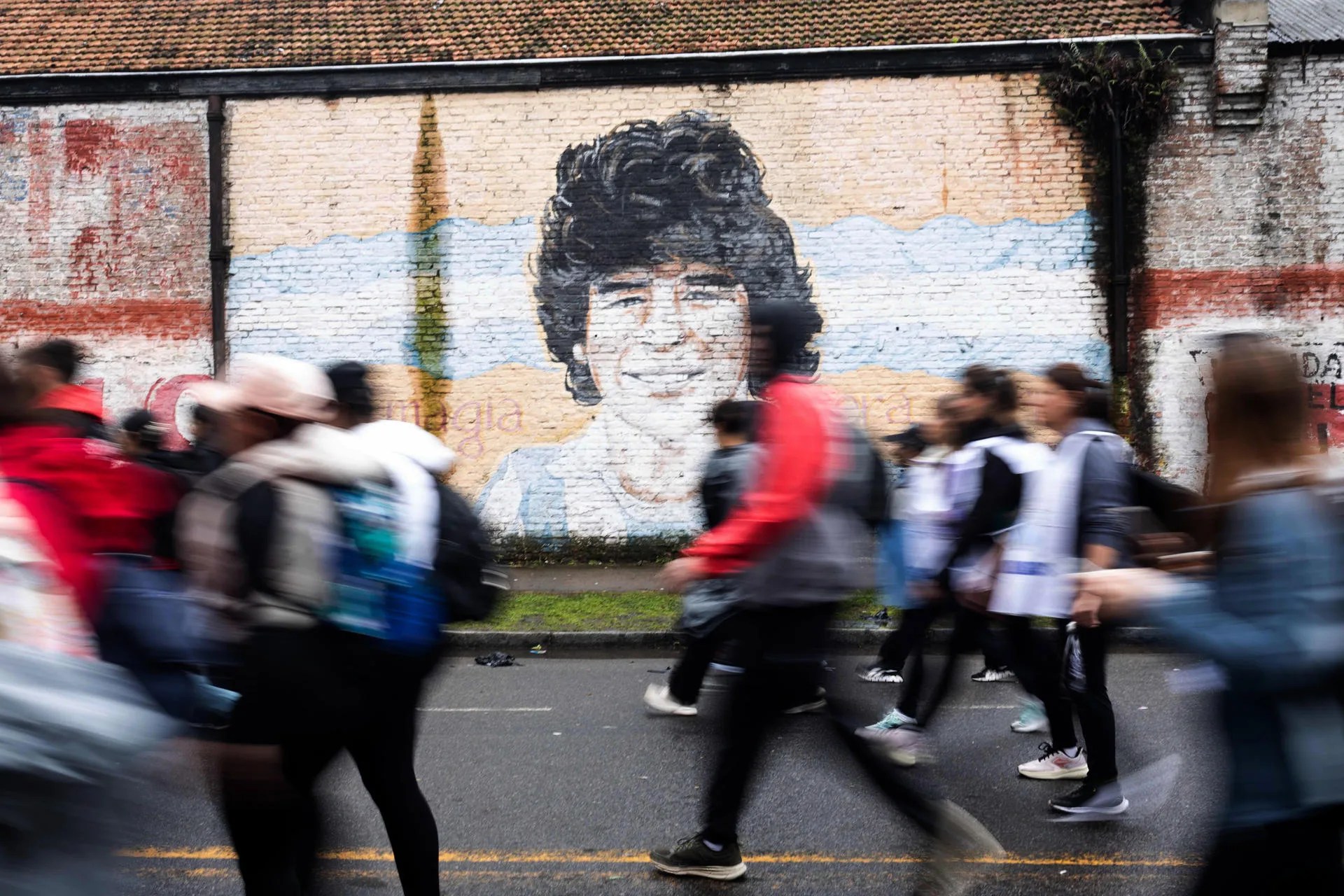 People walk next to an image of Diego Armando Maradona in Lujan, Buenos Aires province, Argentina, 03 October 2026. EFE/ STR