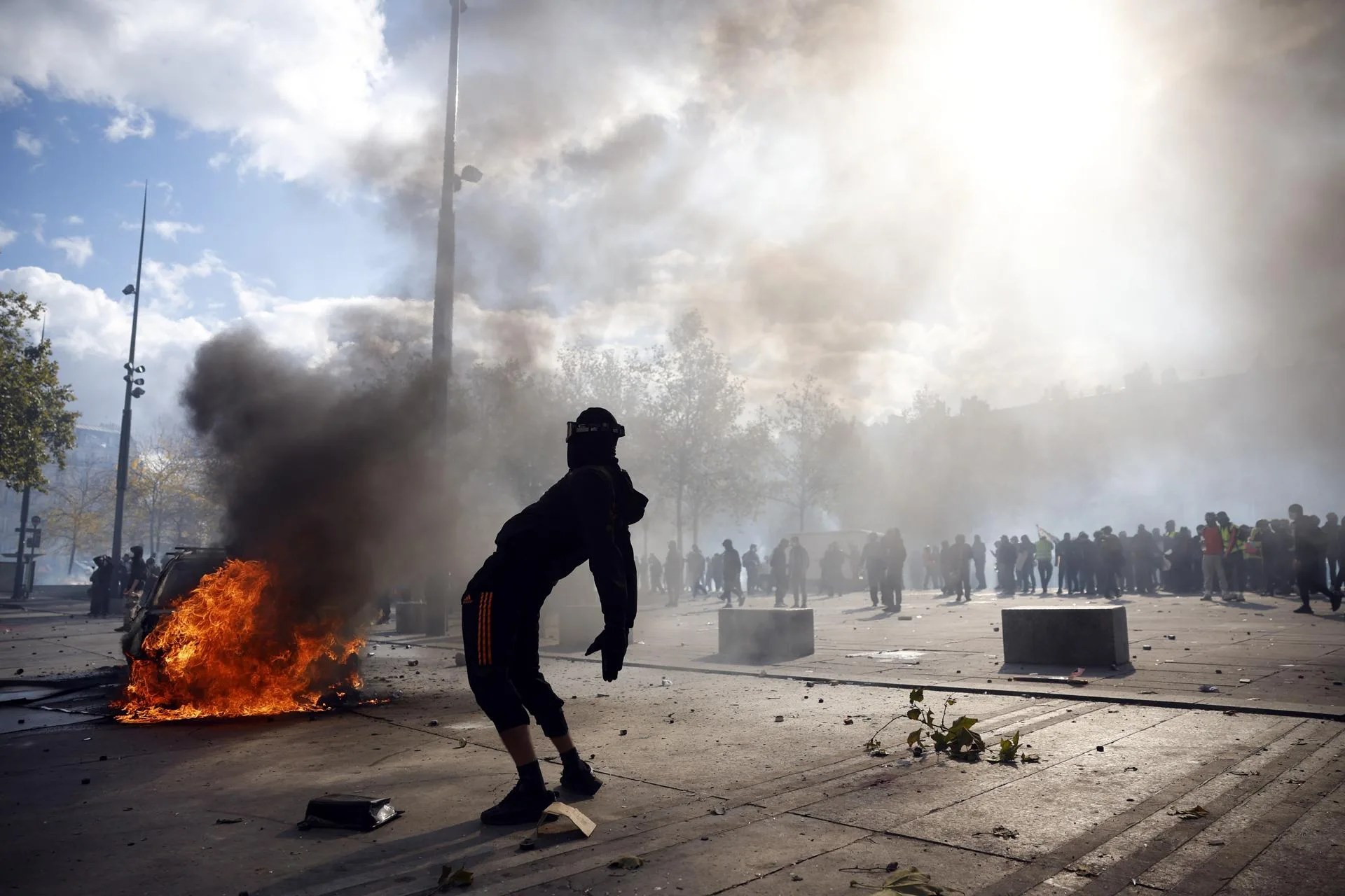 A protester stands amid smoke beside a fire during clashes between protesters and police at Place de la Republique in Paris, France, 17 October 2026. EFE-EPA/YOAN VALAT
