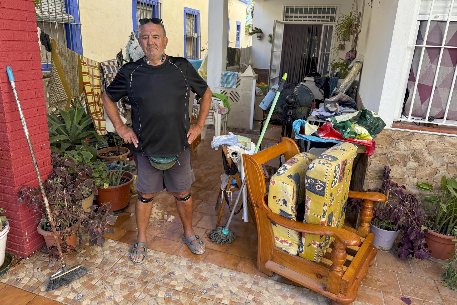 Pedro Meneses, vecino de la playa de Piles (Valencia), posa junto a sus pertenencias dañadas por el agua. EFE/Raquel Segura
