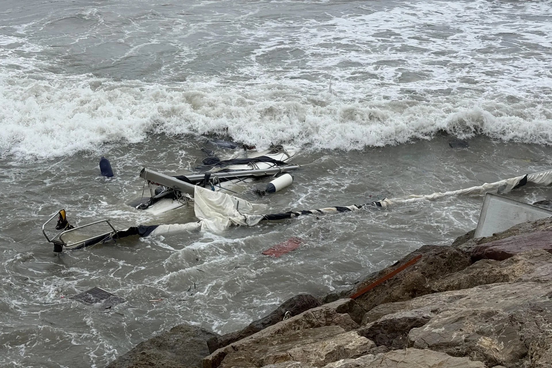 VALENCIA, 19/10/2026.- Dos agentes de Policía han rescatado este lunes al tripulante de un velero varado en un espigón del puerto de Valencia, estando en alerta naranja. EFE/Raquel Segura
