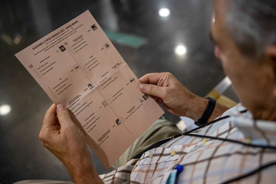 Un hombre observa una papeleta de los candidatos políticos al Senado