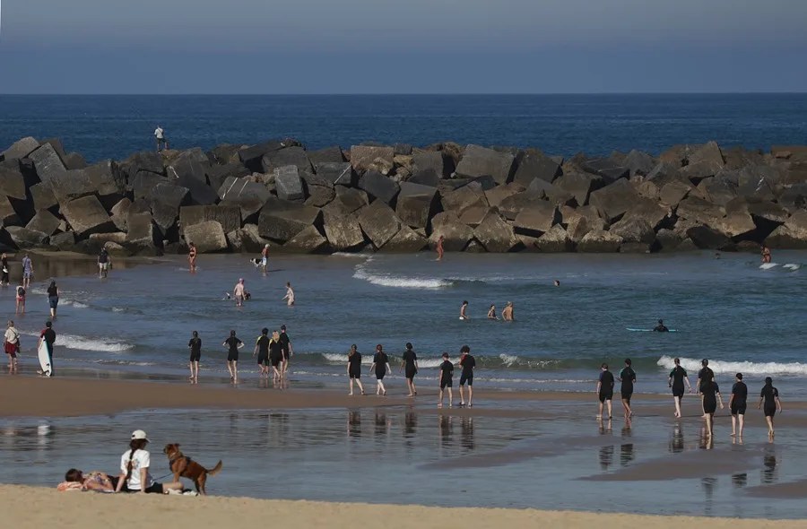 Bañistas y paseantes disfrutan este miércoles de un día soleado en la playa de la Zurriola de San Sebastián