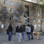 Unos niños de la zona permanecen cerca del lugar donde impactó un dron ruso contra un edificio escolar en una zona residencial de Kiev