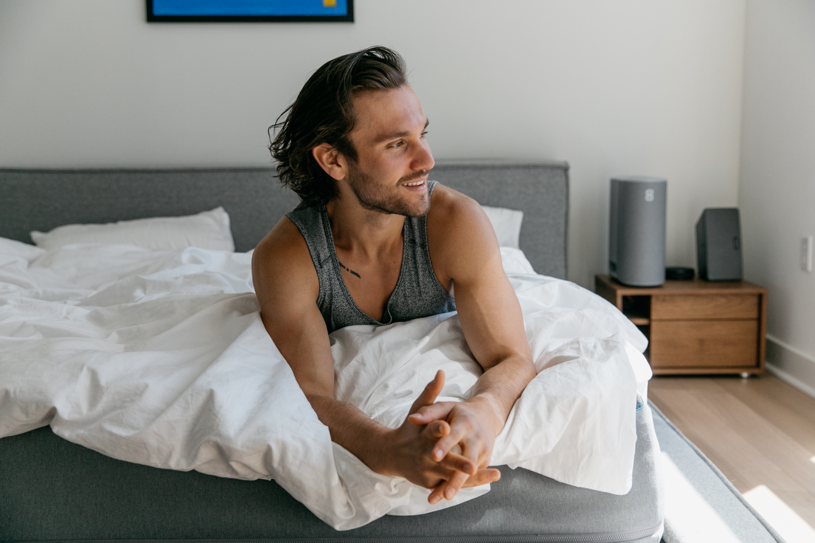 man sitting and smiling in bed