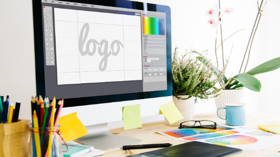 computer showing the word "log" in a stylized font on a cluttered desk