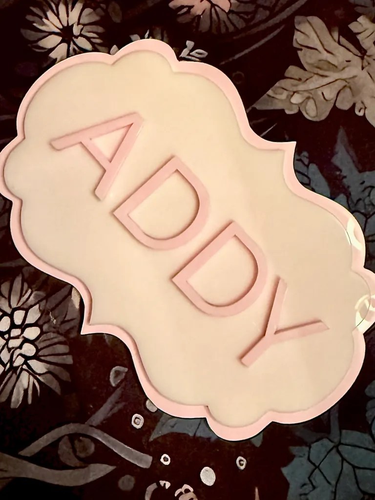 White and pink acrylic piece featuring Alpha Delta Pi Greek letters