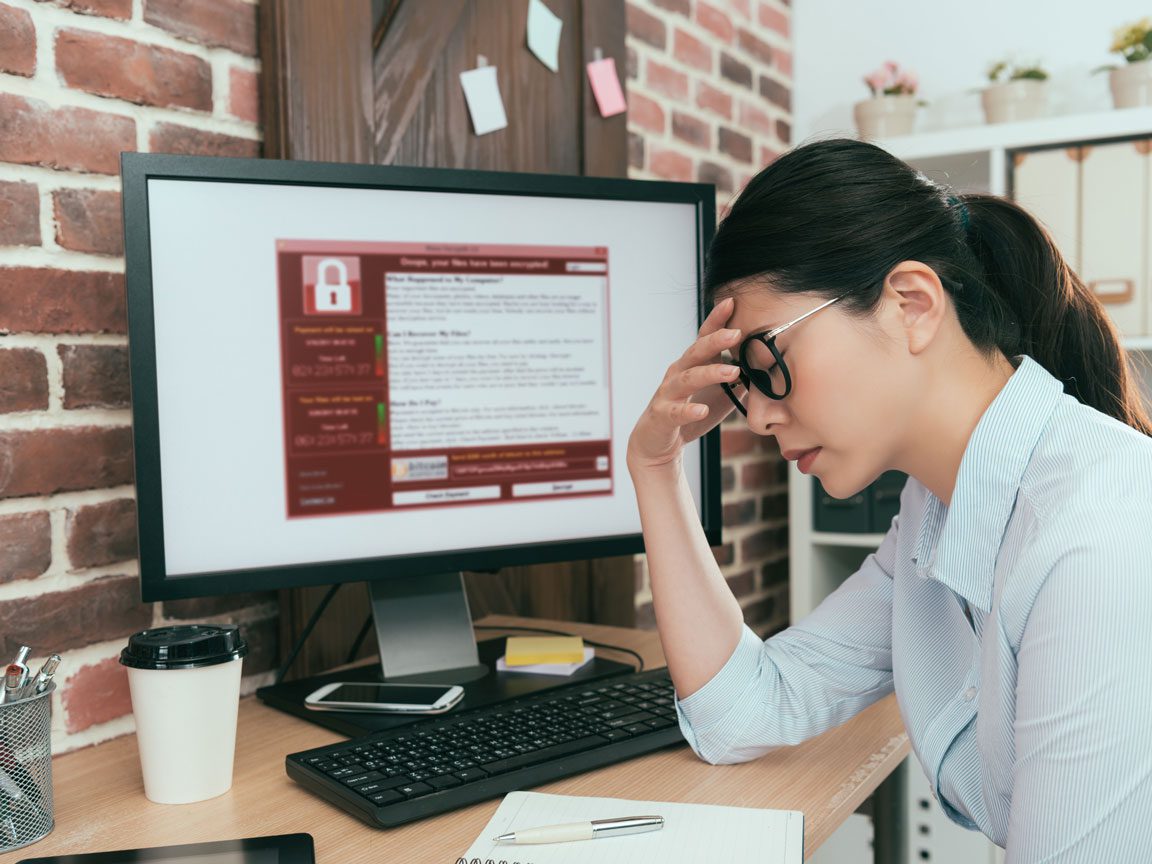 female in front of computer with ransomware