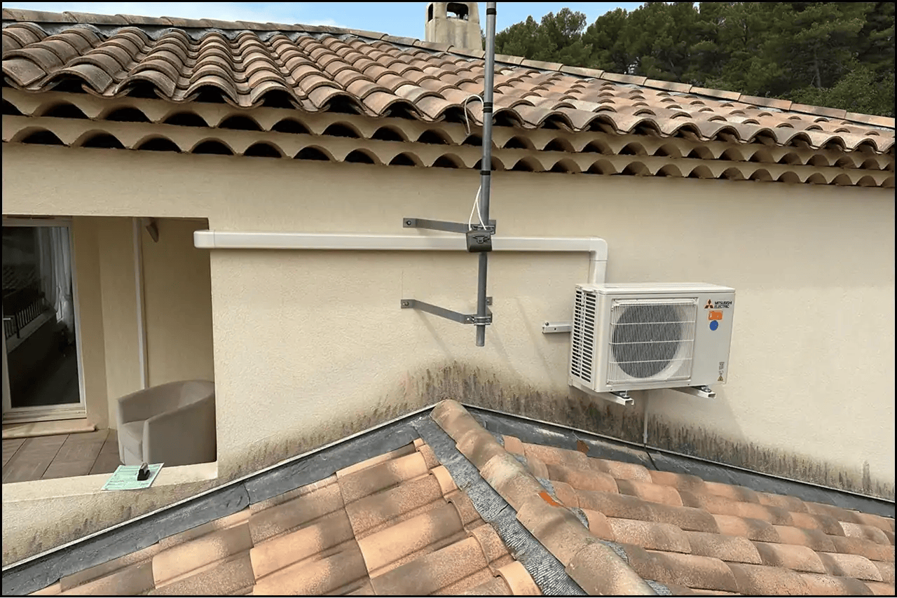 Unité extérieure de climatisation fixée sur la façade d'une maison provençale
