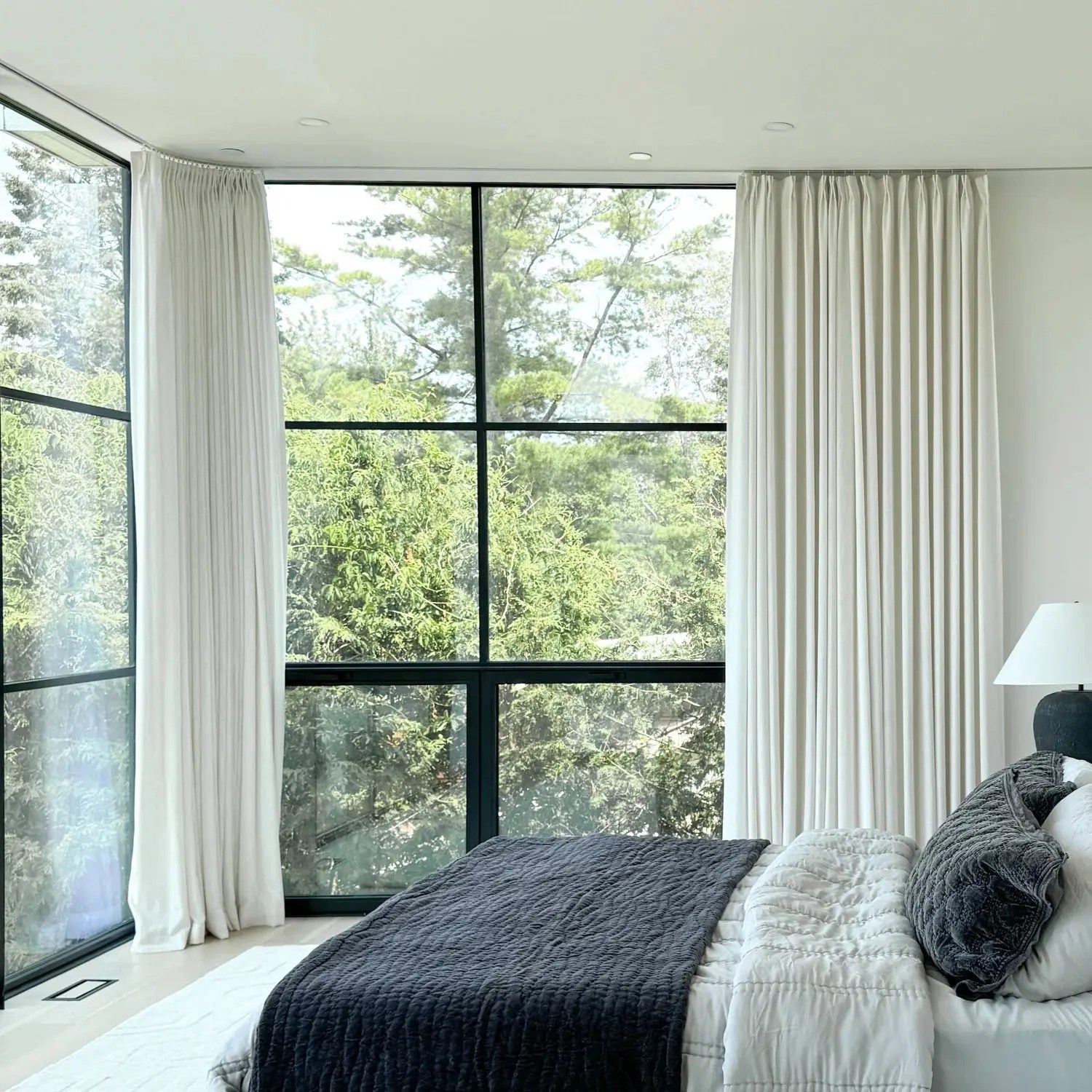Soft textured linen drapery in a bright neutral bedroom with floor-to-ceiling windows, adding warmth, softness, and a quiet luxury interior feel.