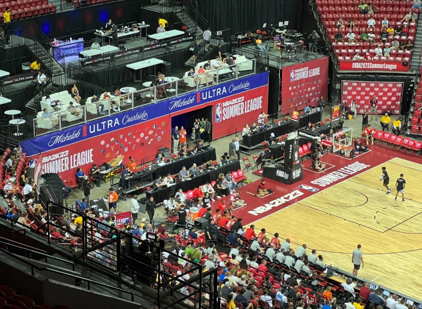 NBA Summer League arena with courtside banners, team logos and spectators