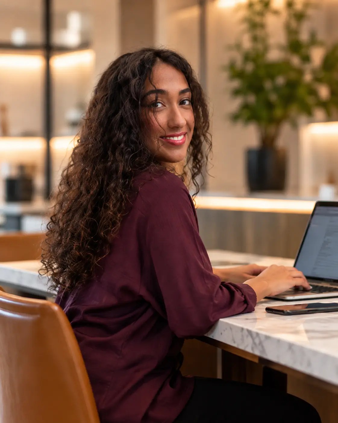 Mariam Khalifa working on a laptop in a modern office