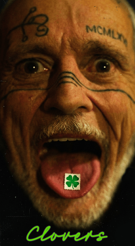 A surprised man with tattoos on his face and a four-leaf clover image on his tongue, with "Clovers" written below.