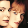 Close-up of the 4K UHD poster for "PRACTICAL MAGIC," featuring two women with dark and red hair, respectively, and the tagline "There's a little witch in every woman" at the bottom right.
