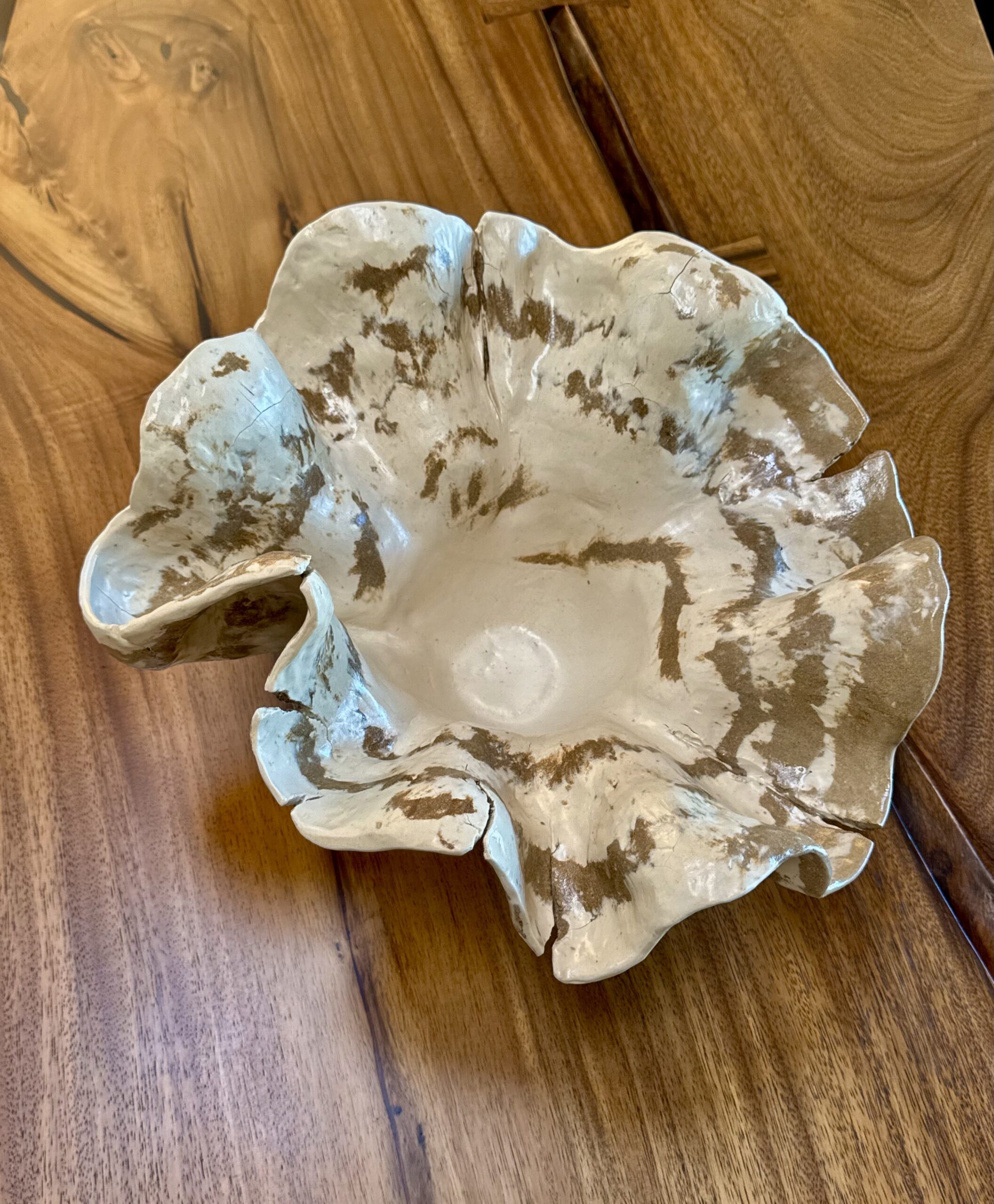 This large handcrafted ceramic bowl features an organic, sculptural form inspired by mountains. The combination of brown and white color clays coiled in a spontaneous pattern gives a dynamic flow of color patterns and reminds you of a marble stone. Every curve carries the memory of touch - intentionally imperfect and alive. Showing detail.