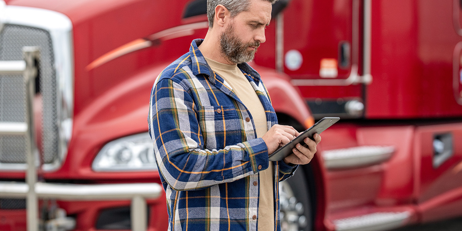 Truck driver viewing in-cab navigation screen with custom route restrictions set by fleet managers